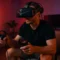 Homme concentré en pleine session de VR gaming à domicile, équipé d’un casque de réalité virtuelle Pimax